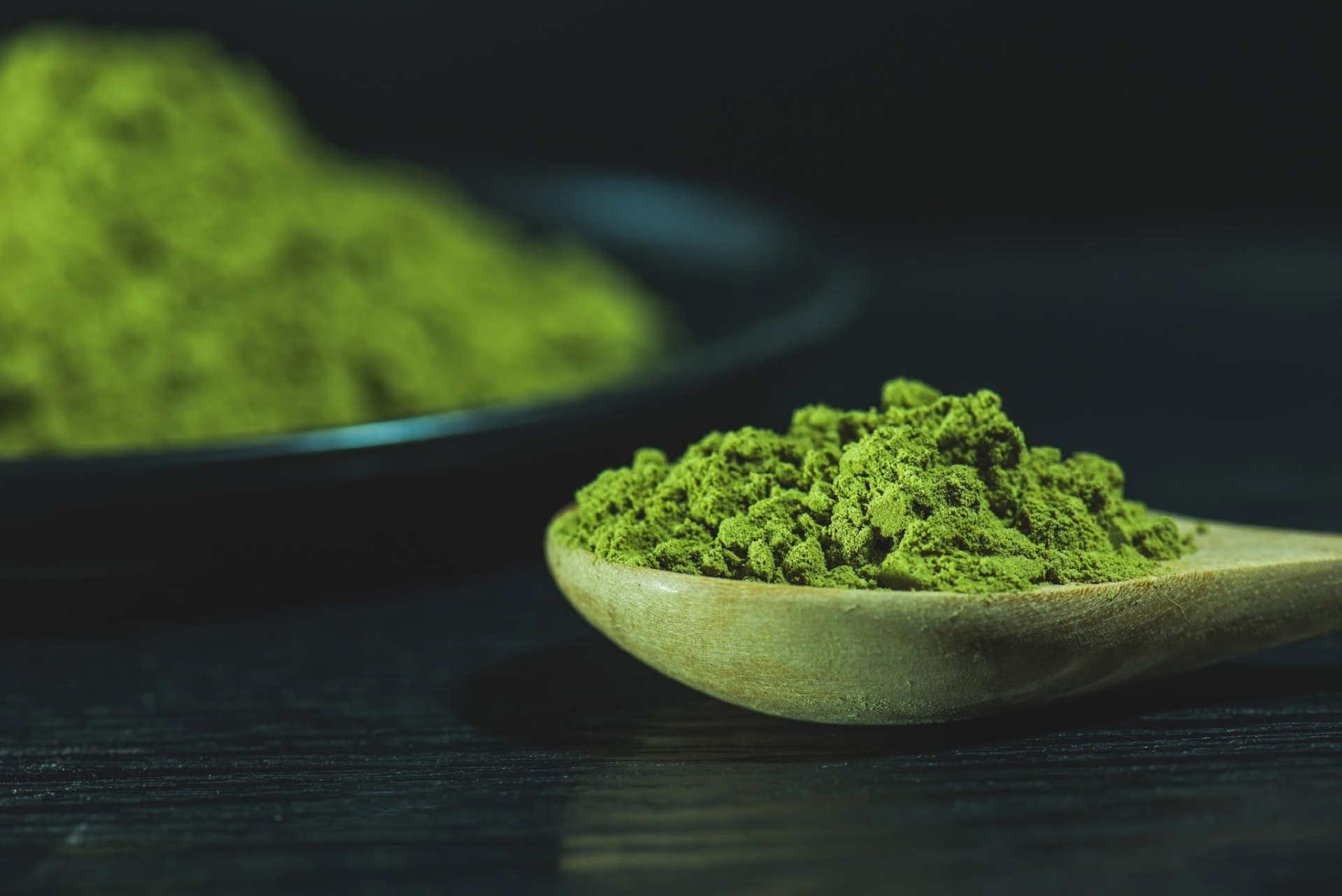Organic Kumamoto matcha powder on a wooden spoon